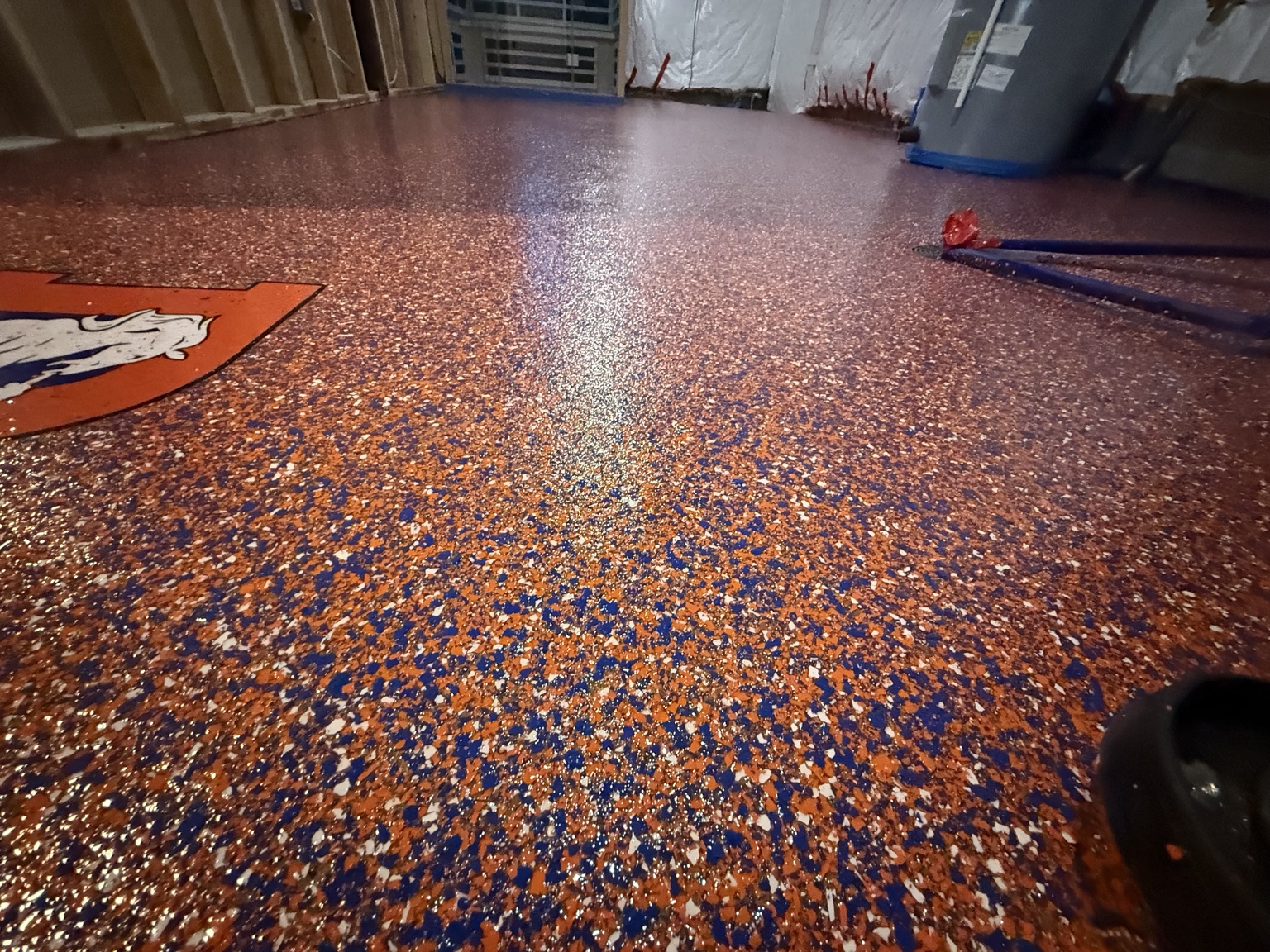 Custom orange and blue flake floor installed in a garage