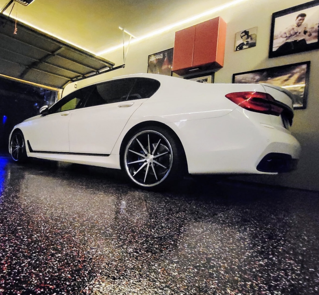 Dark decorative flake floor beneath a white car in a finished garage
