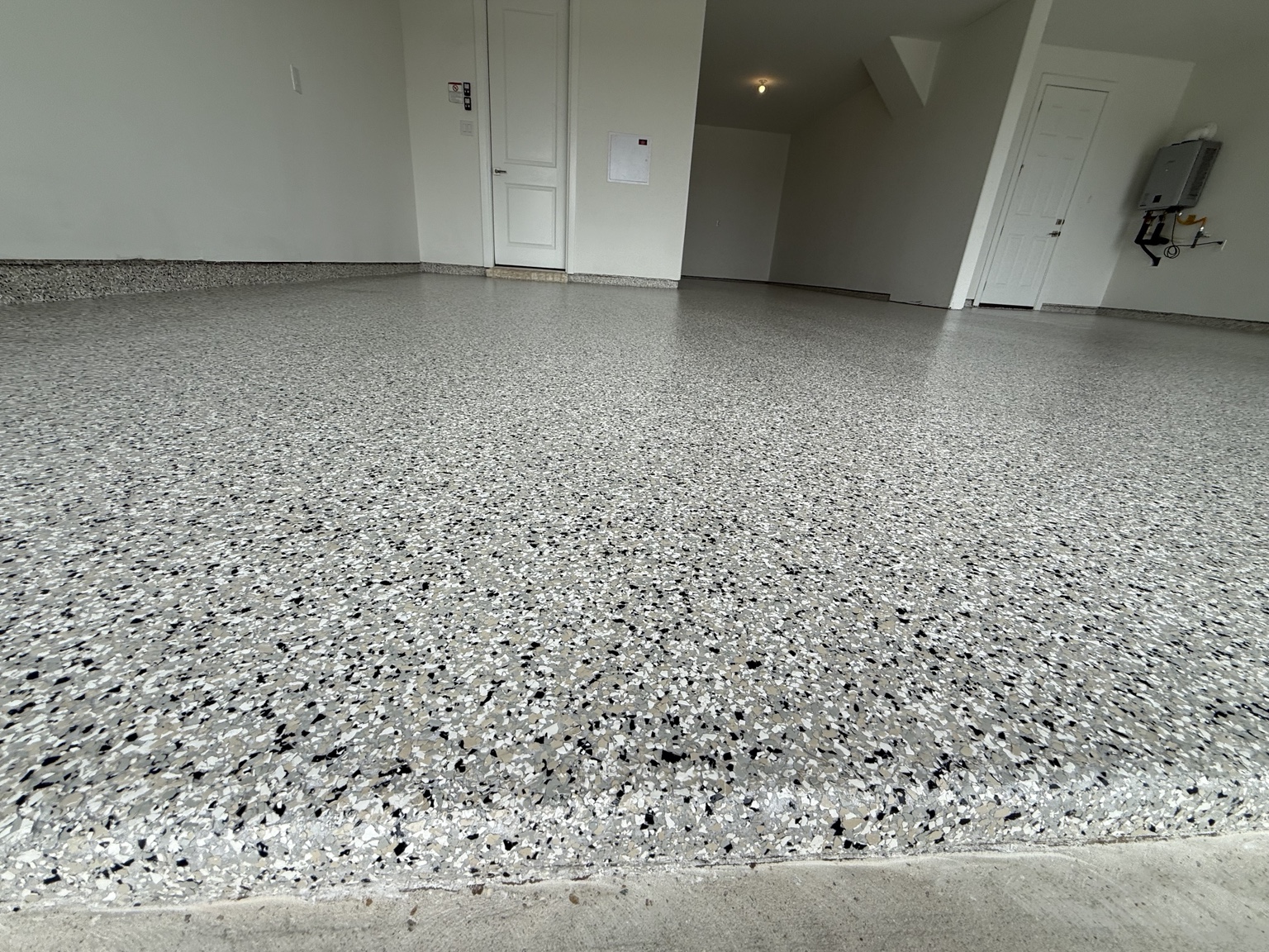 Close view of a gray and black flake floor with coated garage perimeter